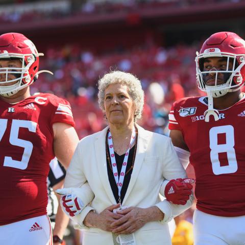 Susan Robeson stands between two Rutgers football players
